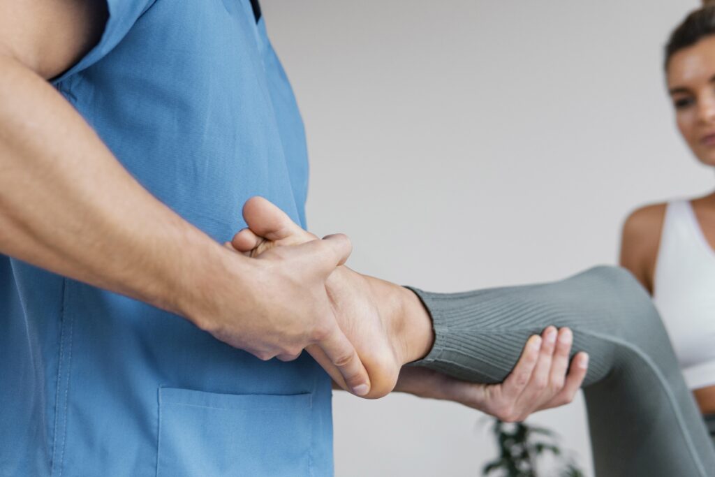 low angle male osteopathic therapist checking female patient s leg movement